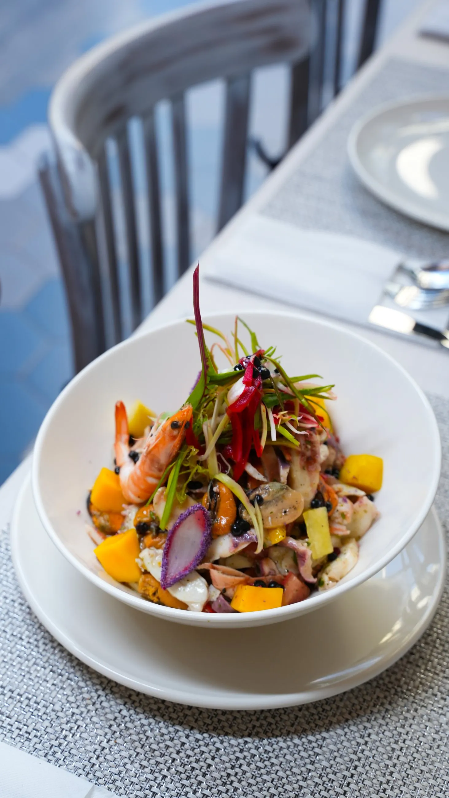 A generous seafood salad topped with a whole prawn