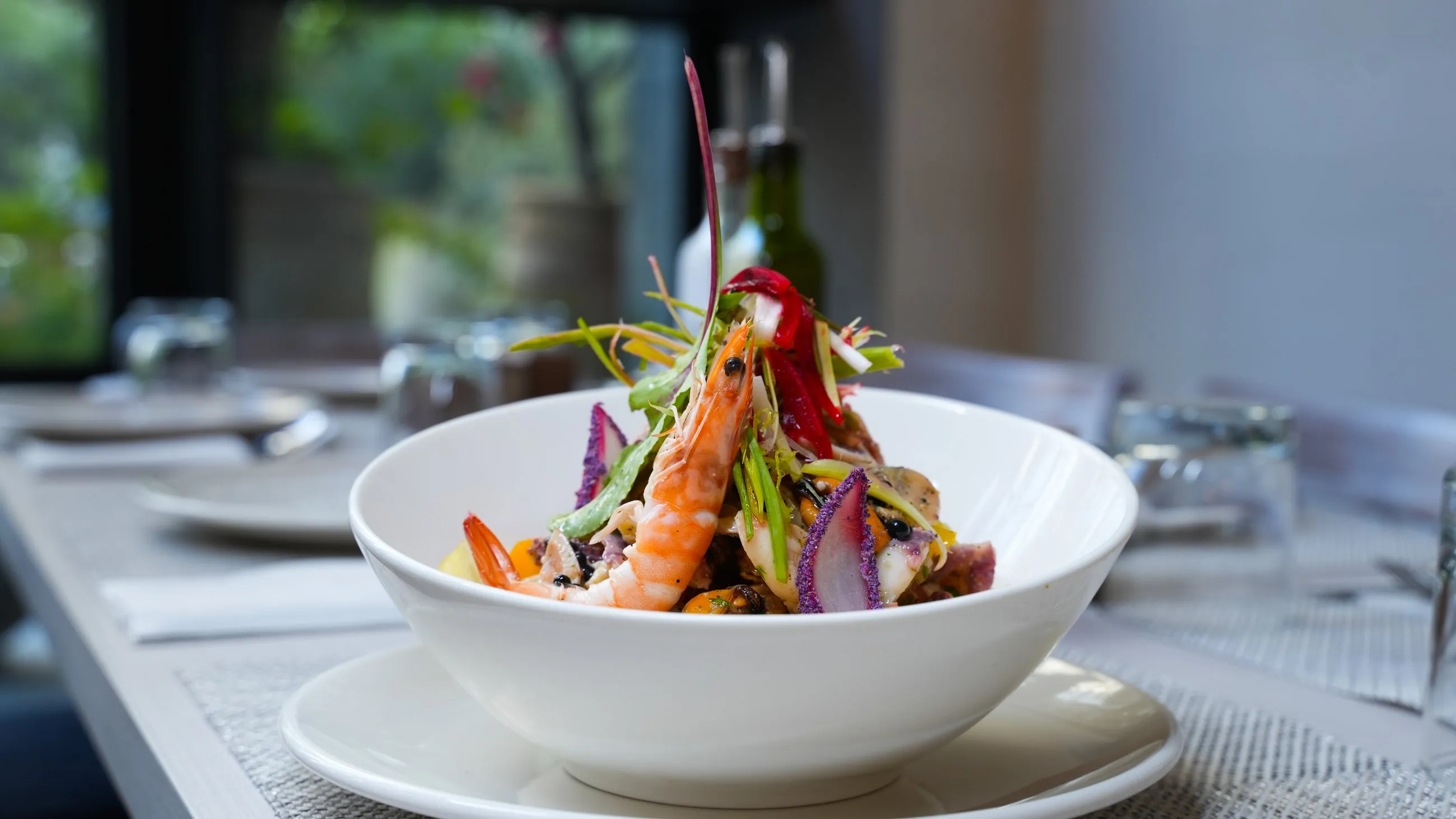 A generous seafood salad topped with a whole prawn