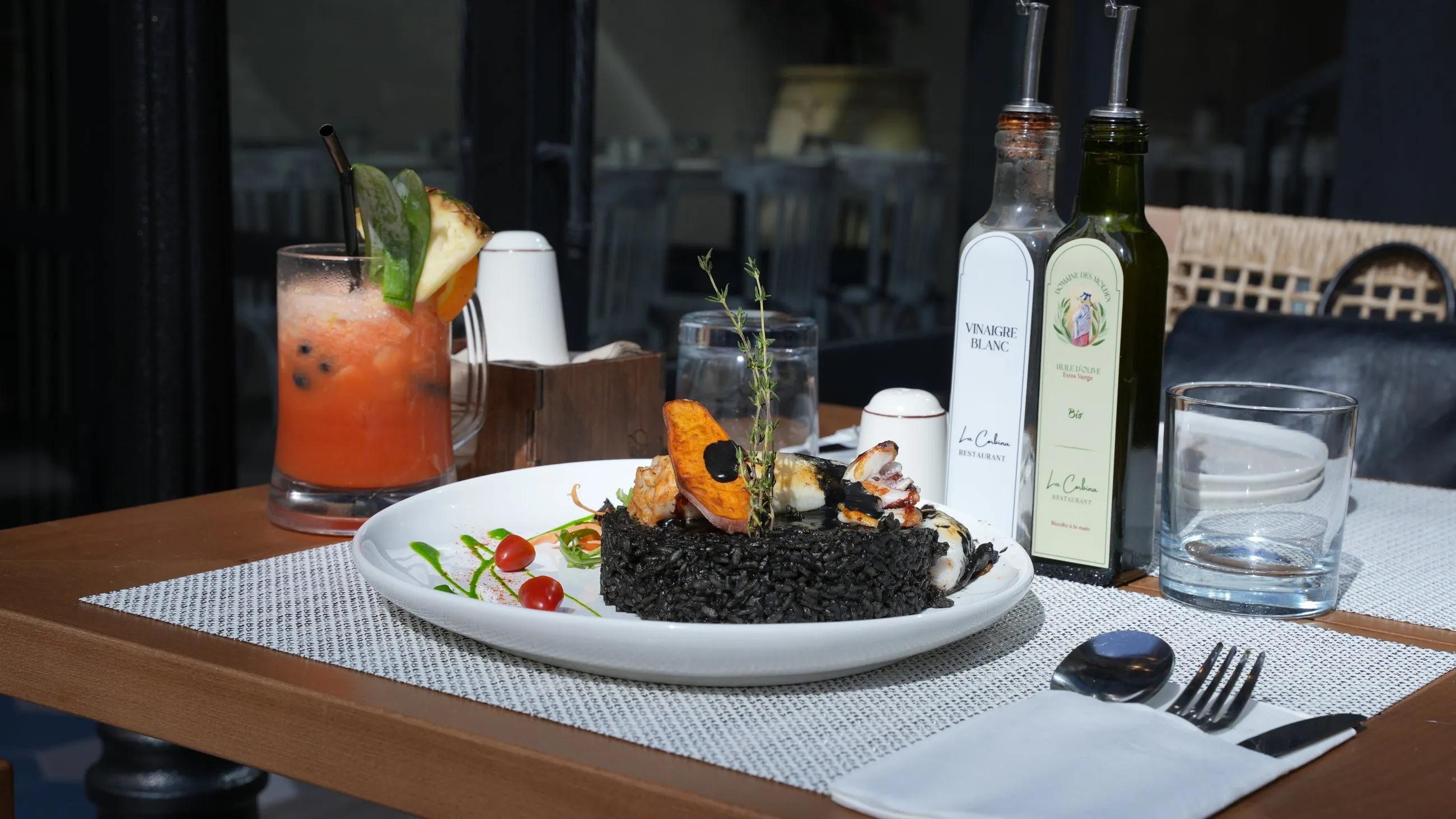 Black seafood rice served with a fresh citrus drink